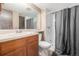 Well-lit bathroom featuring a vanity, toilet, and shower with curtain, offering a functional and tidy space at 8335 Fairmount Dr # 4-102, Denver, CO 80247