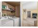 Bright laundry room features white appliances, storage shelf, and is conveniently located near the living space at 8335 Fairmount Dr # 4-102, Denver, CO 80247