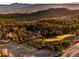Aerial view of a neighborhood surrounded by trees with mountains in the distance at 7332 Woodglen Pl, Castle Pines, CO 80108