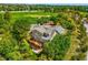 Aerial view of a private home surrounded by mature trees with expansive back deck at 7332 Woodglen Pl, Castle Pines, CO 80108