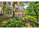 View of the backyard featuring brick exterior, a deck and mature trees at 7332 Woodglen Pl, Castle Pines, CO 80108