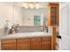 Well-lit bathroom with wood cabinets, a large mirror, and tiled countertops at 7332 Woodglen Pl, Castle Pines, CO 80108