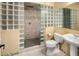 Modern bathroom with glass block shower, updated fixtures, and a pedestal sink at 7332 Woodglen Pl, Castle Pines, CO 80108