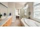 Spacious bathroom featuring a separate glass-enclosed shower, tub, and dual vanities with great natural light at 7332 Woodglen Pl, Castle Pines, CO 80108
