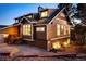 Exterior view of the house at dusk showing brick, siding and dormer windows at 7332 Woodglen Pl, Castle Pines, CO 80108