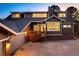 Exterior shot of a brown home with a dark roof and a brick foundation at 7332 Woodglen Pl, Castle Pines, CO 80108