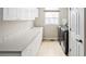Well-lit laundry room with white cabinetry, utility sink, and modern washer and dryer at 7332 Woodglen Pl, Castle Pines, CO 80108