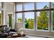 Sun-filled living room with large windows showcasing picturesque outdoor views and a balcony at 7332 Woodglen Pl, Castle Pines, CO 80108