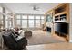 Spacious living room with fireplace, entertainment center, and large windows at 7332 Woodglen Pl, Castle Pines, CO 80108