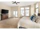 Spacious bedroom with plush carpet, private balcony access, and a ceiling fan at 7332 Woodglen Pl, Castle Pines, CO 80108