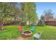 Backyard with chairs surrounding a firepit and various mature trees and shrubs at 4285 Newland St, Wheat Ridge, CO 80033