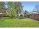 A lush green backyard with a shed and mature evergreen trees and shrubs at 4285 Newland St, Wheat Ridge, CO 80033
