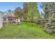 A spacious green backyard featuring a patio, firepit, shed, and mature trees for shade at 4285 Newland St, Wheat Ridge, CO 80033