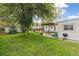 Landscaped backyard with a patio, dining set under a pergola, a grill, and a storage shed at 4285 Newland St, Wheat Ridge, CO 80033