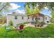 Landscaped backyard featuring a fire pit, pergola, dining set, and well-maintained lawn at 4285 Newland St, Wheat Ridge, CO 80033