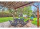 Backyard patio features a table and chairs with a pergola with firepit in the background at 4285 Newland St, Wheat Ridge, CO 80033