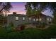 Backyard featuring a fire pit, pergola, dining set, and well-maintained lawn at dusk at 4285 Newland St, Wheat Ridge, CO 80033