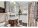 The bathroom features modern grey tiling, dark wood cabinet, and a patterned shower curtain at 4285 Newland St, Wheat Ridge, CO 80033