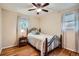 Comfortable bedroom featuring a metal bed frame, hardwood floors, and natural light from two windows at 4285 Newland St, Wheat Ridge, CO 80033