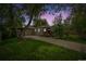 Inviting home at dusk featuring a covered carport, attached garage, and cozy front porch at 4285 Newland St, Wheat Ridge, CO 80033