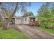 Charming single-story home featuring a detached garage and a cozy front porch with wood trim details at 4285 Newland St, Wheat Ridge, CO 80033