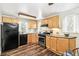 Well-lit kitchen with wood cabinets, appliances, and dark wood-look floors at 4285 Newland St, Wheat Ridge, CO 80033