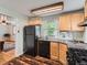 This charming kitchen features wooden cabinets, a black refrigerator, and a gas stove at 4285 Newland St, Wheat Ridge, CO 80033