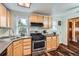 Functional kitchen featuring wooden cabinets, stainless steel appliances, and a corner sink with natural light at 4285 Newland St, Wheat Ridge, CO 80033