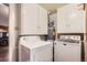 Convenient laundry area with overhead cabinets, washer, and dryer, and hot water heater at 4285 Newland St, Wheat Ridge, CO 80033