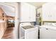 Functional laundry room with modern washer, dryer, and overhead storage cabinets at 4285 Newland St, Wheat Ridge, CO 80033