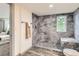 Bathroom features gray marble tile shower, and updated vanity at 4445 Milwaukee St, Denver, CO 80216