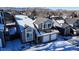 Aerial view of a two-story house with attached garage, snowy landscape at 6765 Tabor St, Arvada, CO 80004