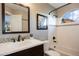 Clean bathroom with white tile, updated fixtures, and a shower/tub combo at 6765 Tabor St, Arvada, CO 80004