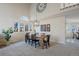 Bright dining room with a farmhouse table, six black chairs, and a large window at 6765 Tabor St, Arvada, CO 80004