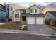 Two-story home with gray siding, two-car garage, and a landscaped yard at 6765 Tabor St, Arvada, CO 80004