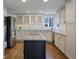 Modern kitchen featuring granite island, stainless steel appliances, and white cabinets at 6765 Tabor St, Arvada, CO 80004