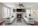 Bright living room featuring a stone fireplace, built-in shelving, and comfortable sofas at 10532 Wintersweet Ct, Parker, CO 80134