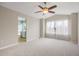 Bright main bedroom with carpet floors, ceiling fan, and view to the en suite bathroom at 10532 Wintersweet Ct, Parker, CO 80134