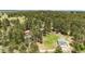 Expansive aerial shot showcases wooded acreage with a green outbuilding on a lush lot at 8788 E Tanglewood Rd, Franktown, CO 80116