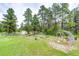 Large backyard with a chicken coop, garden beds, and mature trees, offering a serene and private outdoor space at 8788 E Tanglewood Rd, Franktown, CO 80116