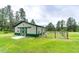 Exterior view of a large barn with green trim, set on a spacious lawn, perfect for agricultural pursuits at 8788 E Tanglewood Rd, Franktown, CO 80116