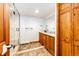 Modern bathroom with double vanity, stone tile flooring, and glass enclosed shower at 8788 E Tanglewood Rd, Franktown, CO 80116