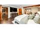 Spacious bedroom with hardwood floors, a walk-in closet, and a large TV for entertainment at 8788 E Tanglewood Rd, Franktown, CO 80116