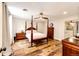 Spacious bedroom featuring a four-poster bed, wood floors and an ensuite bathroom with shower at 8788 E Tanglewood Rd, Franktown, CO 80116