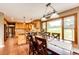 A dining room featuring wood floors, a large window with nature views and a view into the kitchen at 8788 E Tanglewood Rd, Franktown, CO 80116