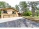 Home exterior featuring a three-car garage, mature trees, and a serene landscape at 8788 E Tanglewood Rd, Franktown, CO 80116
