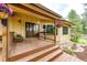 Charming front porch with double doors, wooden steps, and tasteful landscaping at 8788 E Tanglewood Rd, Franktown, CO 80116