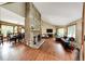 Open-concept living space with hardwood floors, a stone fireplace, and a view of the adjacent dining area at 8788 E Tanglewood Rd, Franktown, CO 80116