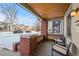 Front porch with brick columns and wicker seating at 4234 N Raleigh St, Denver, CO 80212