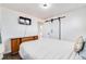 Bedroom featuring hardwood floors, neutral walls, and a sliding barn door closet at 1742 S Alcott St, Denver, CO 80219
